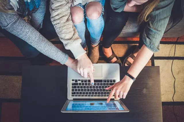 Grupa przyjaciół używa laptopa